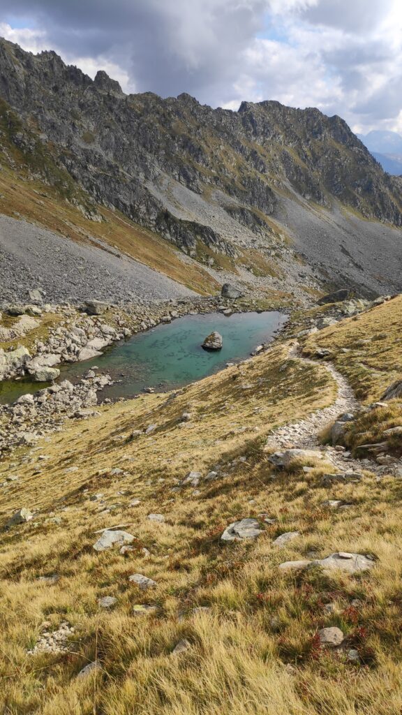Sentier de randonnées dans les Alpes menant à un lac de montagne.